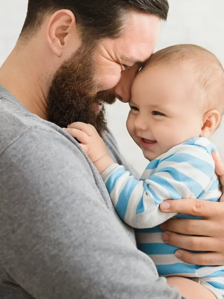 Cheerful father and son cuddling at home, enjoying time together